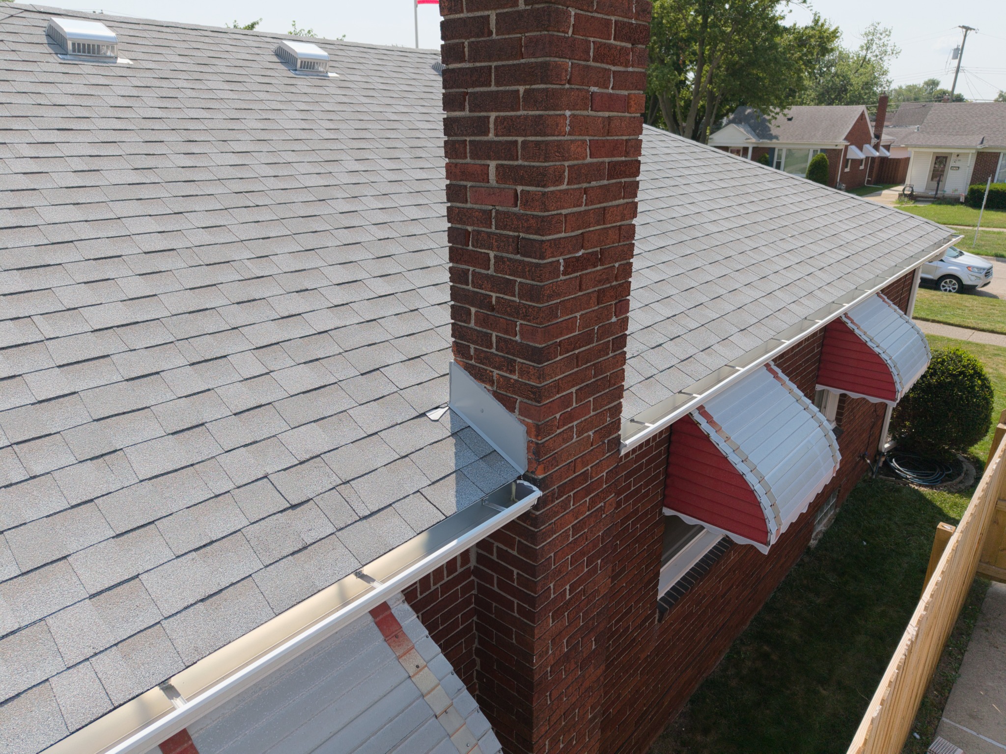 Close aerial view of a brick chimney and roof flashing
