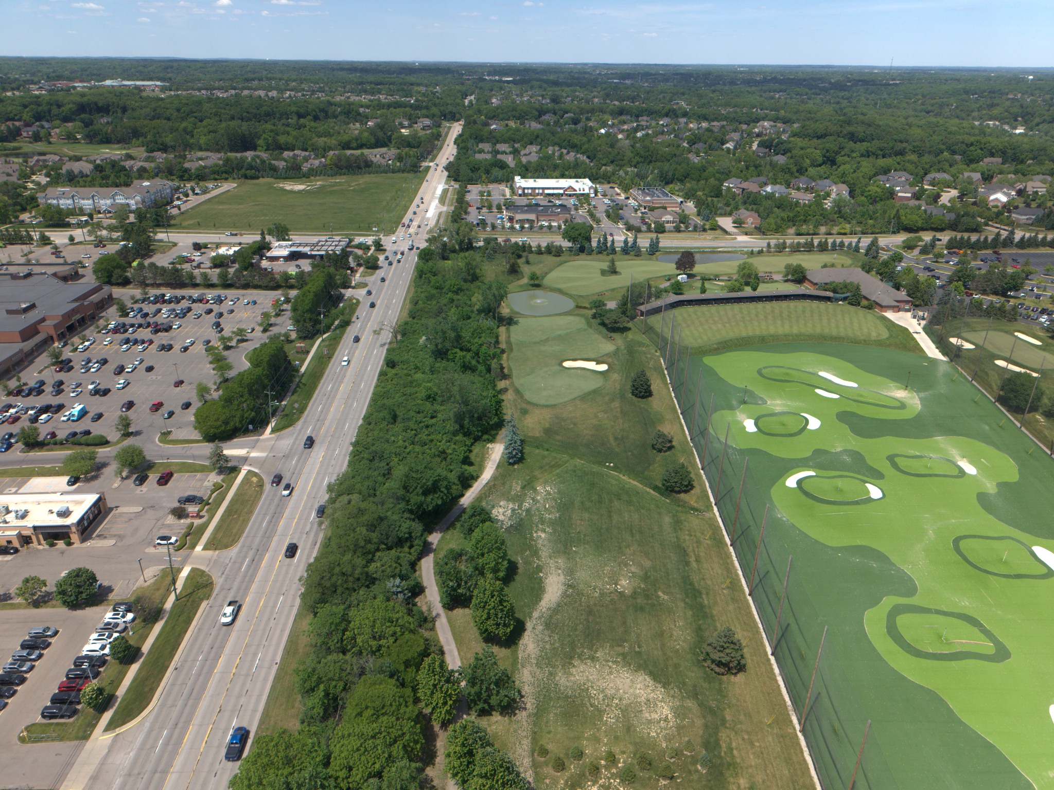 Aerial view of a commercial corridor and golf practice facility