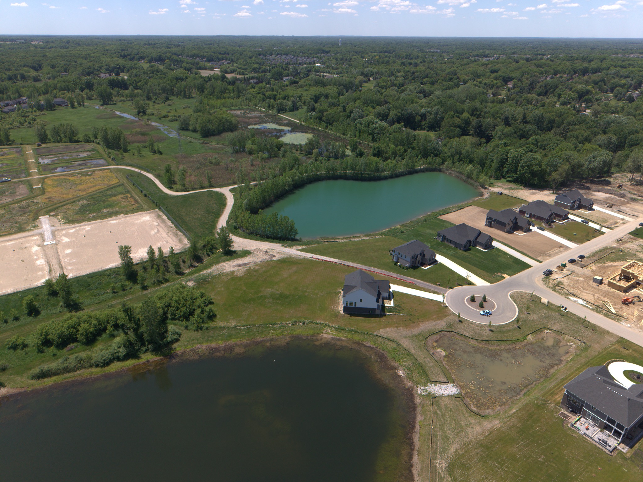 Aerial view of homes, ponds, and surrounding land