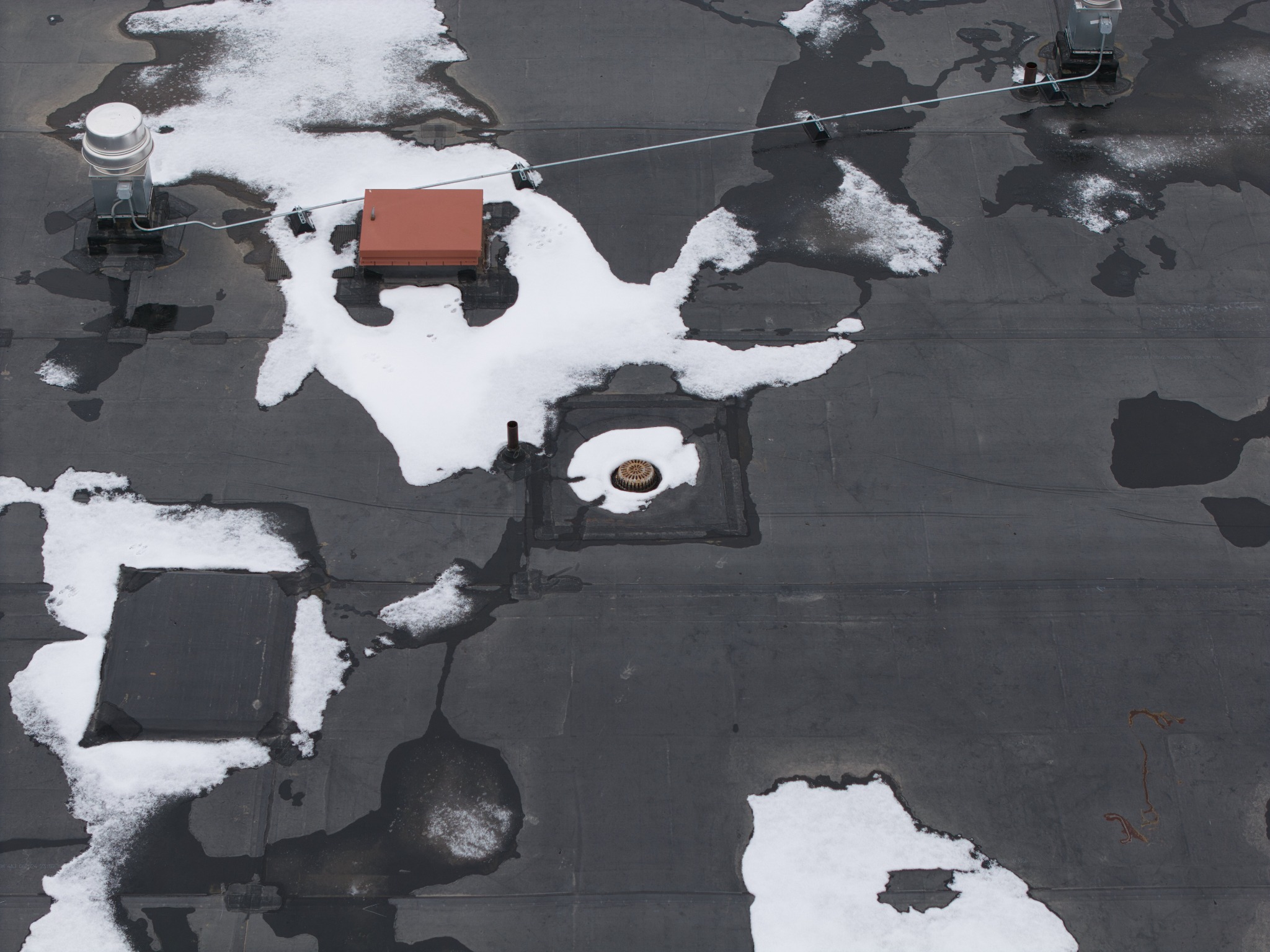 Overhead view of drainage and equipment on a commercial flat roof
